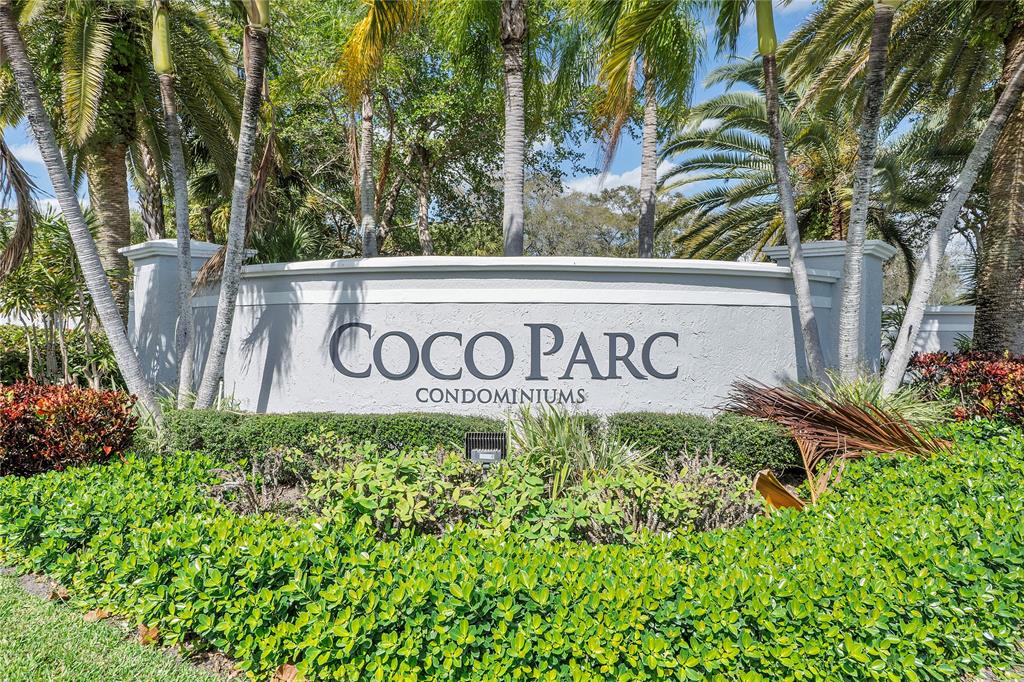 931 Lyons Road, Unit 4204 Coconut Creek, FL 33063 - Photo 13 of 13 a sign broad in front of flowers