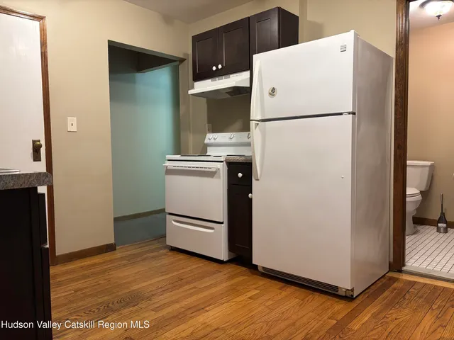 a white refrigerator freezer and a wooden floor