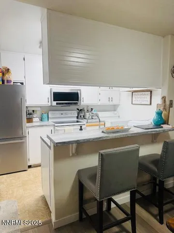 a kitchen with a table chairs refrigerator and cabinets