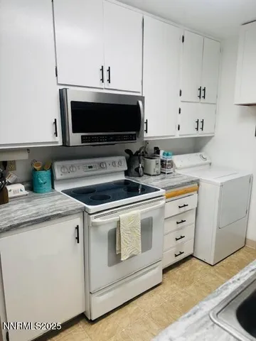 a kitchen with granite countertop a sink a stove and cabinets