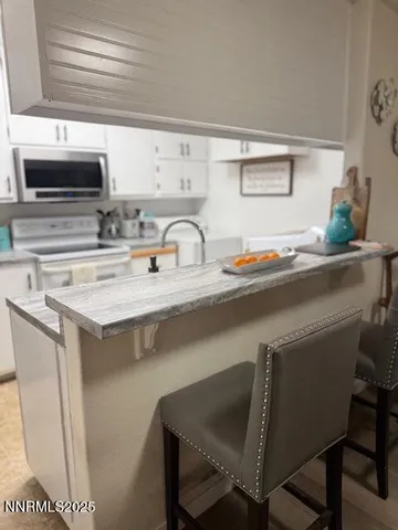 a kitchen with a sink a stove and chairs