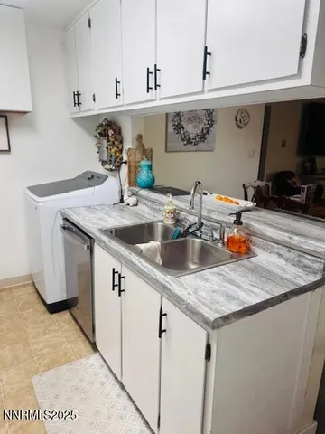 a kitchen with stainless steel appliances granite countertop a sink a stove and white cabinets