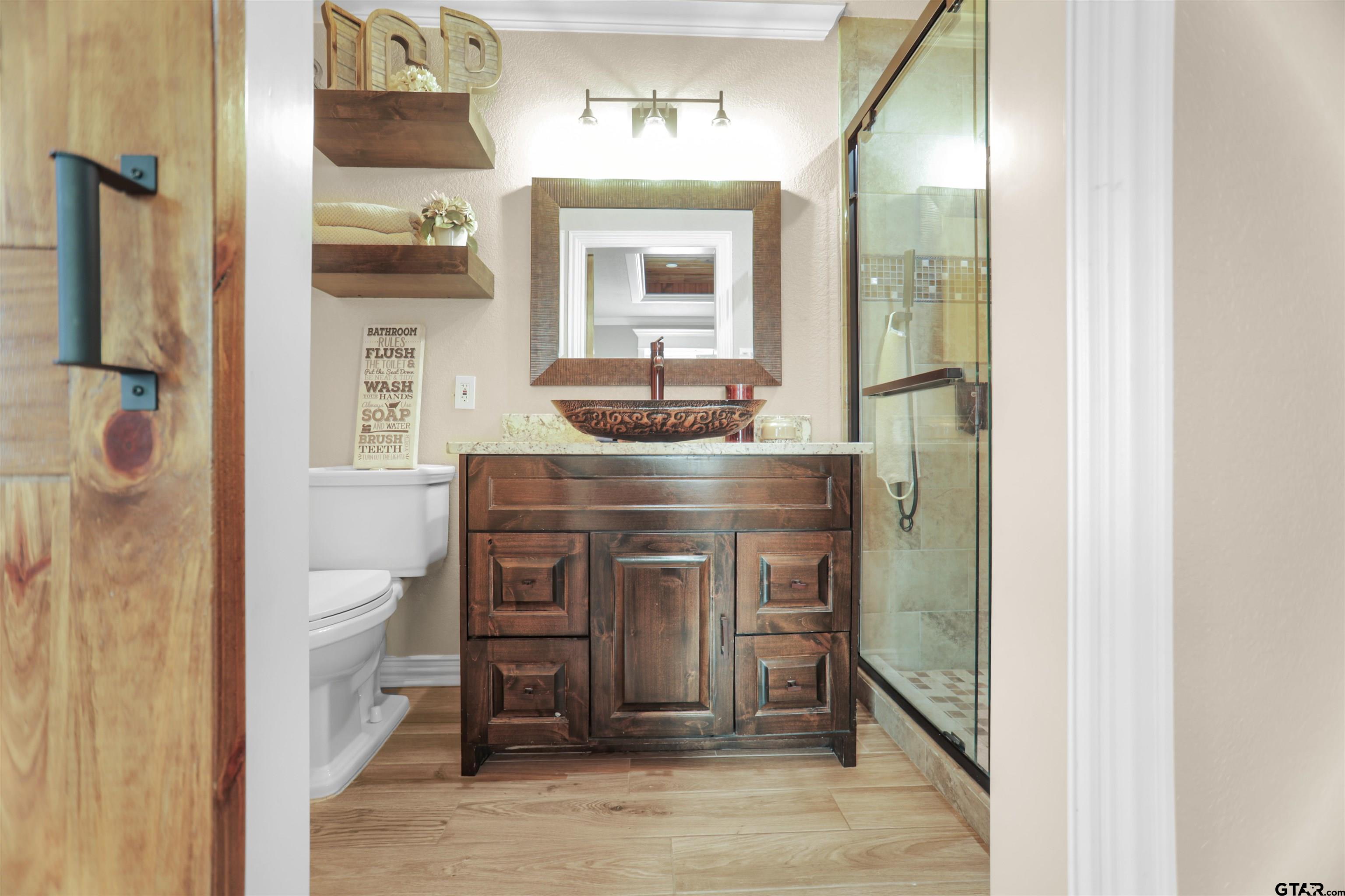 11931 State Highway 64 Tyler, TX 75704 - Photo 13 of 44 a bathroom with a toilet a sink and mirror