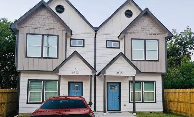 a view of a house with a yard and potted plants