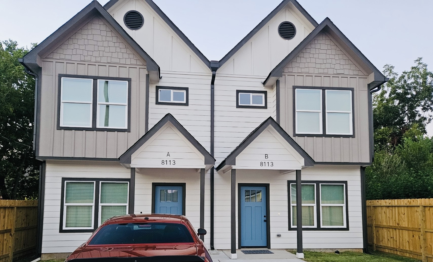a view of a house with a yard and potted plants