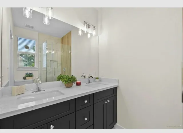 a bathroom with a double vanity sink and a mirror