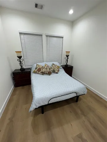 a bedroom with a bed and a potted plant