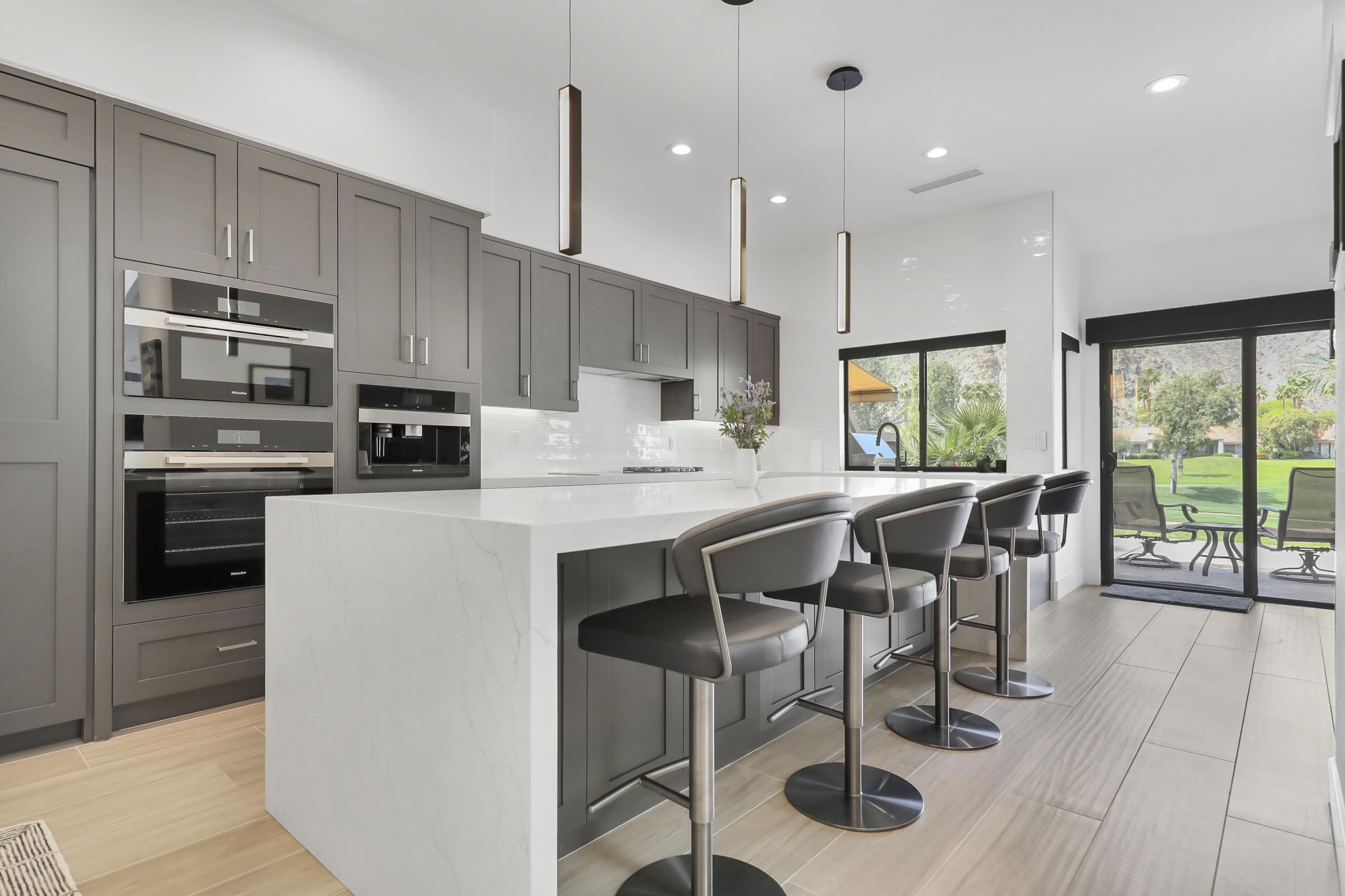 79754 Arnold Palmer La Quinta, CA 92253 - Photo 1 of 38 a kitchen with stainless steel appliances granite countertop a stove a refrigerator a sink a dining table and chairs with wooden floor
