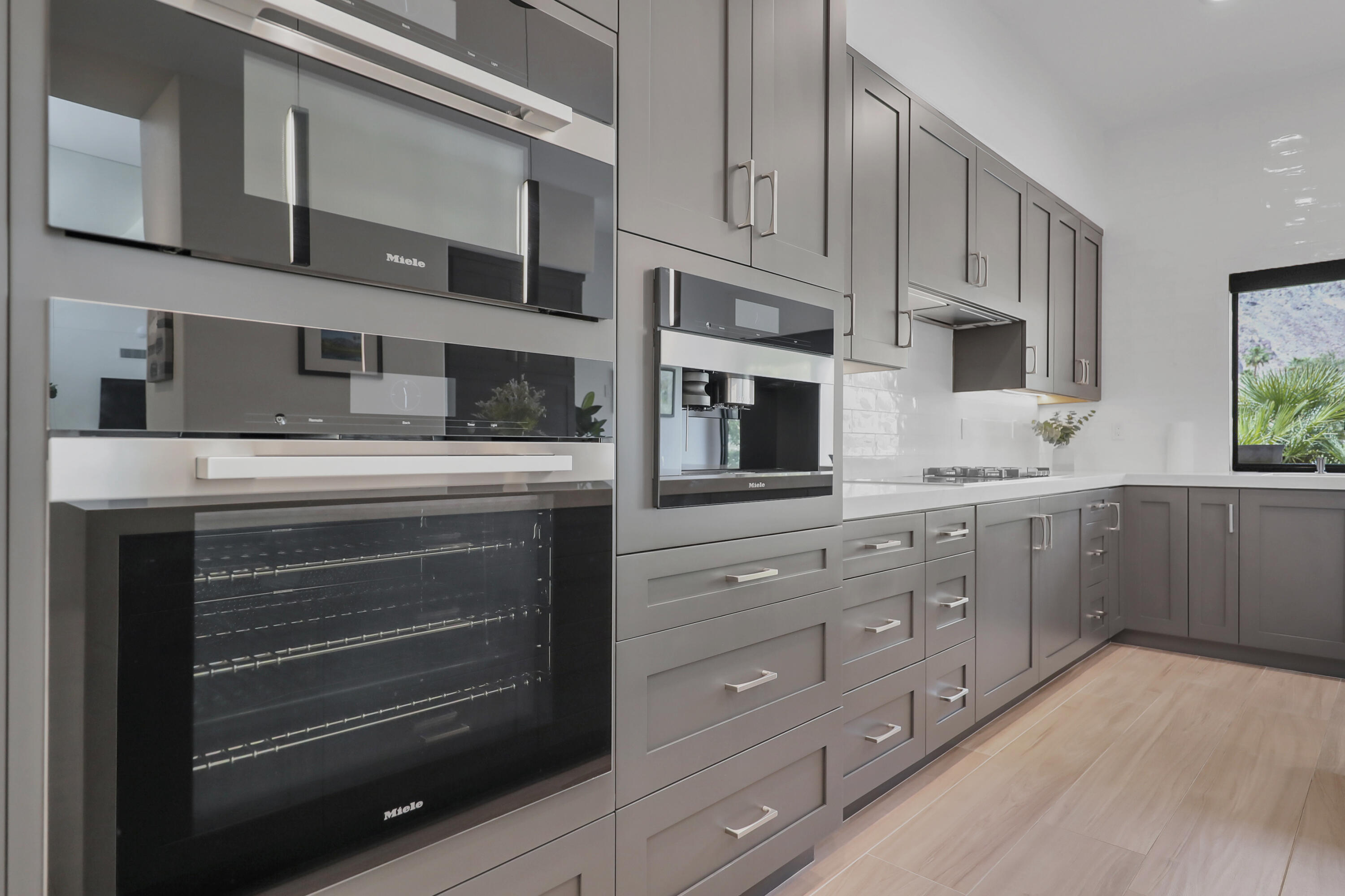 79754 Arnold Palmer La Quinta, CA 92253 - Photo 11 of 38 a kitchen with stainless steel appliances granite countertop a stove microwave and cabinets