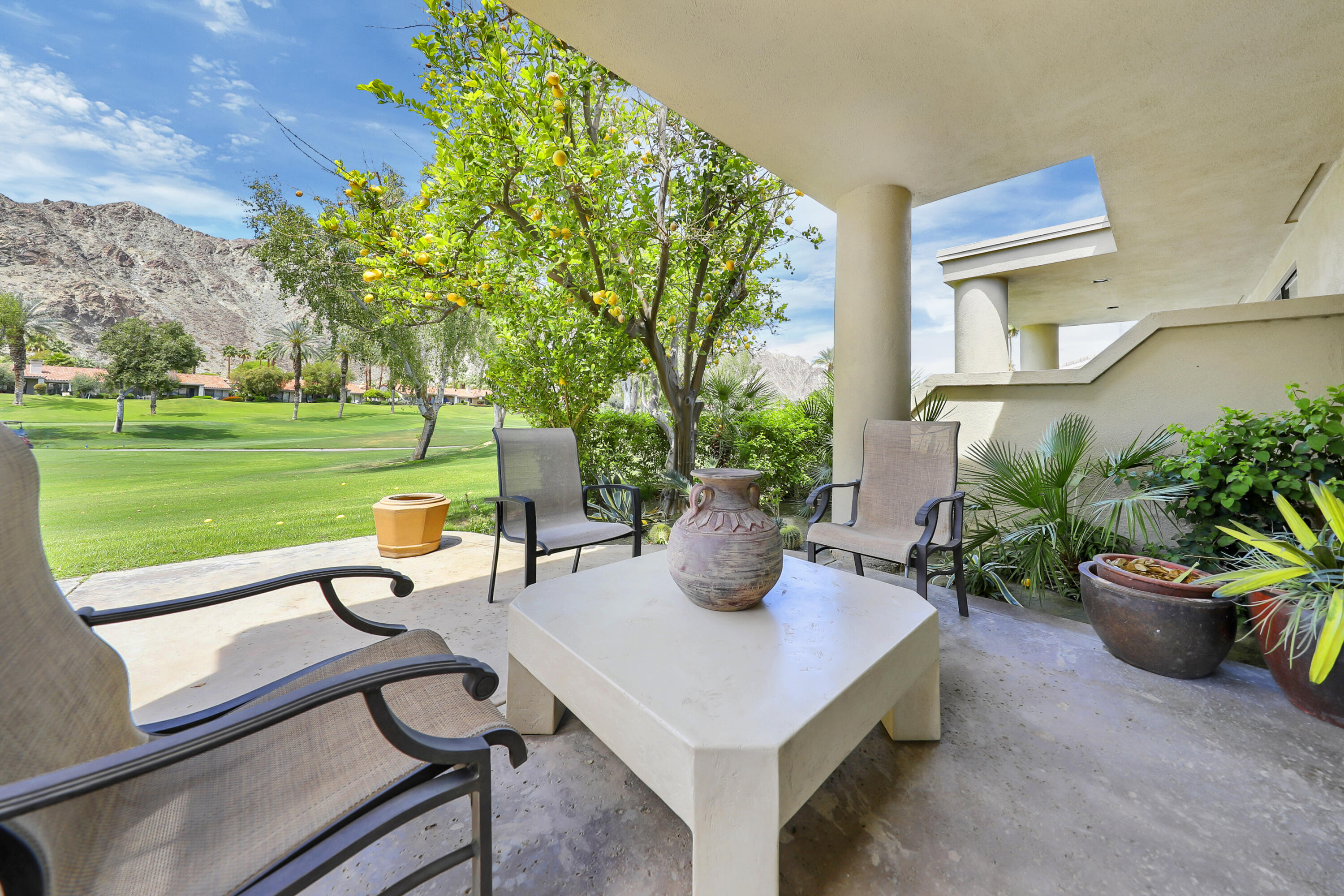 79754 Arnold Palmer La Quinta, CA 92253 - Photo 30 of 38 a view of a patio with table and chairs and potted plants