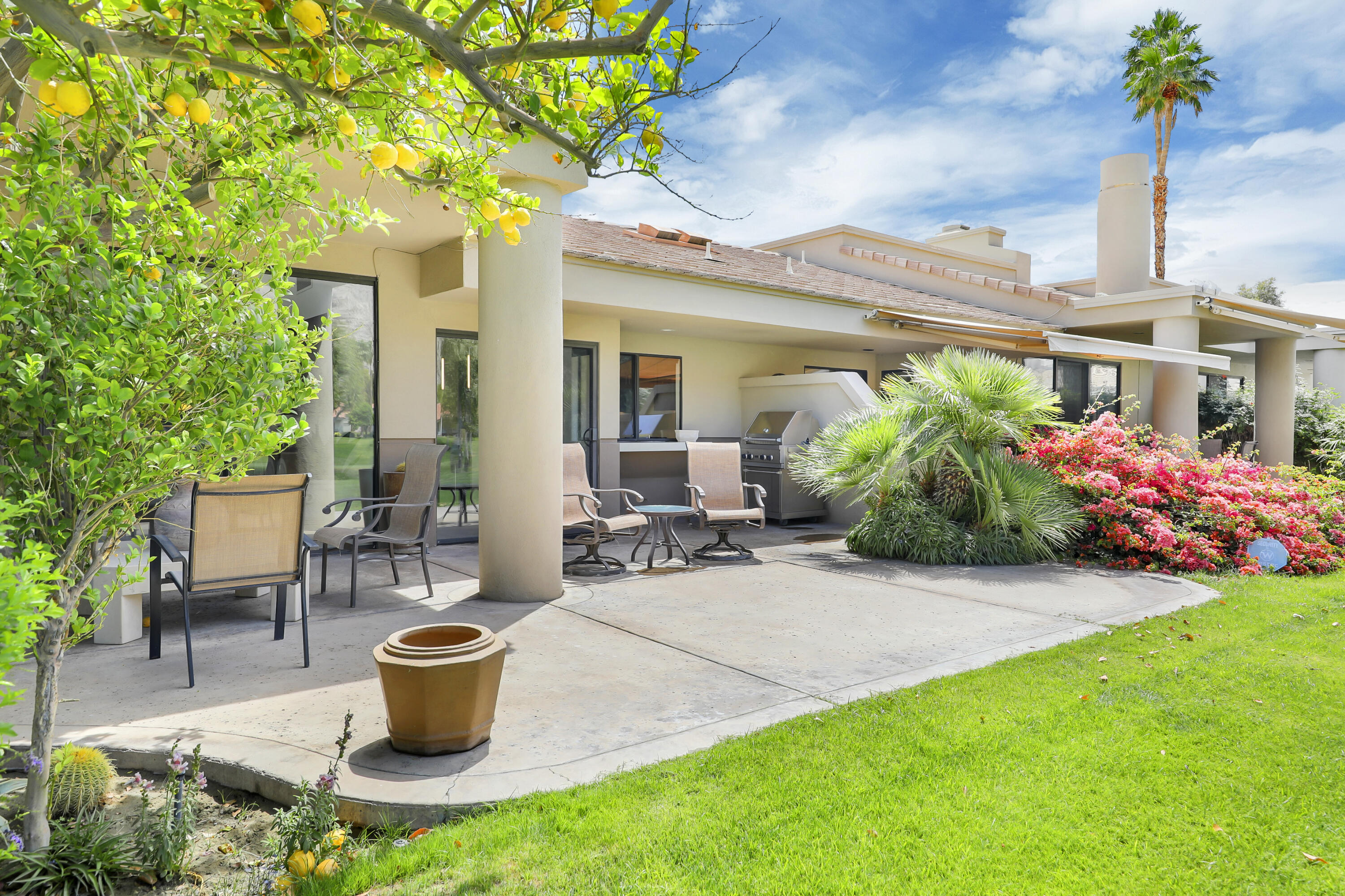79754 Arnold Palmer La Quinta, CA 92253 - Photo 34 of 38 a view of a house with backyard sitting area and garden