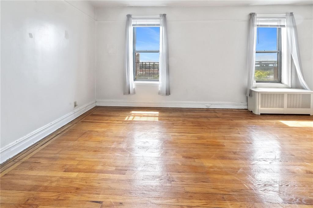 351 Marine Avenue, Unit E18 Brooklyn, NY 11209 - Photo 2 of 13 a view of an empty room with wooden floor and a window