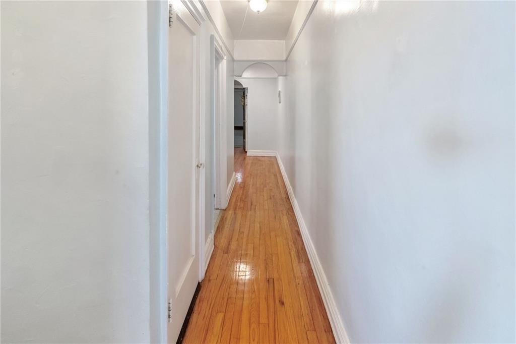 351 Marine Avenue, Unit E18 Brooklyn, NY 11209 - Photo 8 of 13 a view of a hallway with wooden floor and staircase