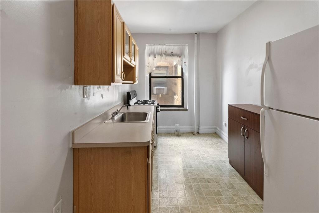 351 Marine Avenue, Unit E18 Brooklyn, NY 11209 - Photo 10 of 13 a kitchen with a refrigerator sink and stove