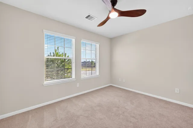 an empty room with a window and a fan