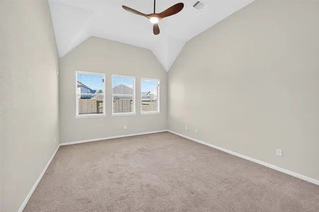 an empty room with windows and fan