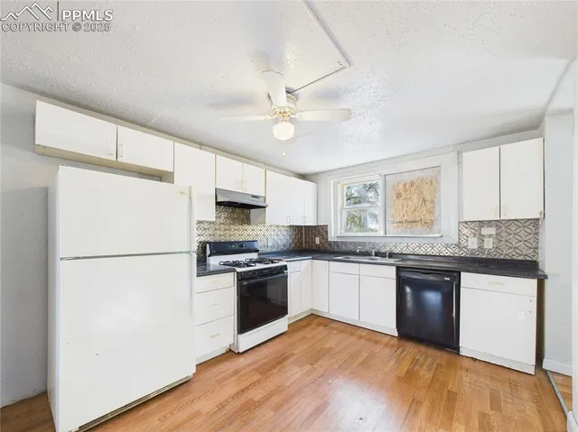 a kitchen with granite countertop stainless steel appliances and wooden floor