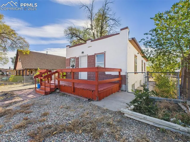 a view of a house with large trees plants and large tree