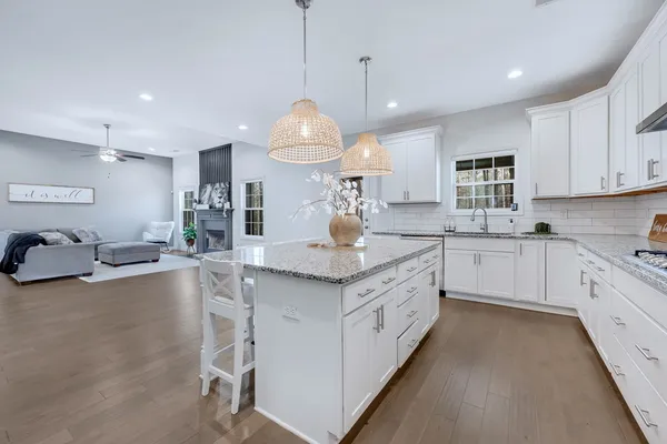 a large kitchen with kitchen island a large counter space a sink stainless steel appliances and cabinets