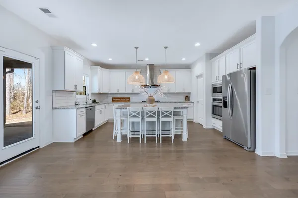 a kitchen with a dining table chairs refrigerator and cabinets
