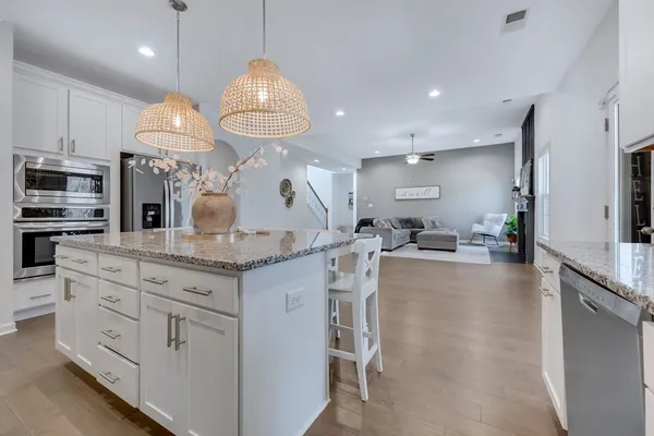 a kitchen with stainless steel appliances granite countertop a sink a stove and a wooden floors