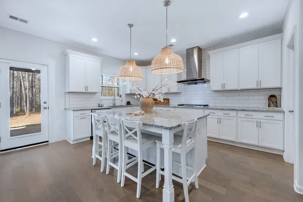 a kitchen with a stove a sink a center island and cabinets