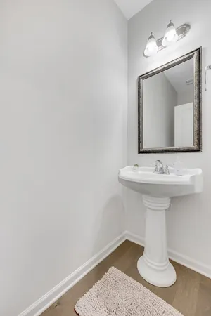 a bathroom with a granite countertop sink a toilet a mirror a vanity and a shower