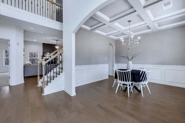 a dining room with furniture wooden floor and a chandelier