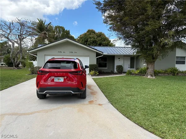a car parked in front of a house with a yard