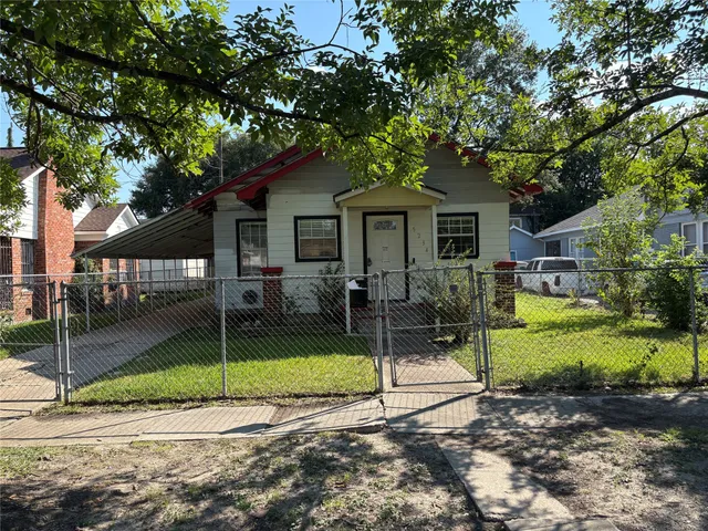 a view of a house with a backyard and a tree