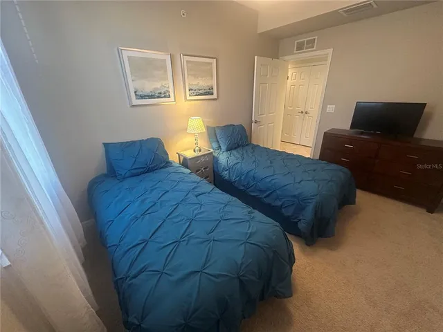 a bedroom with two beds and painting on the wall