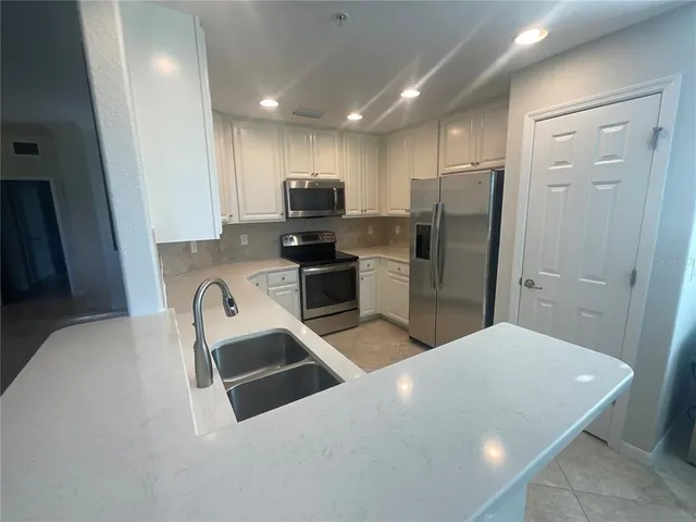 a kitchen with stainless steel appliances a refrigerator and a sink
