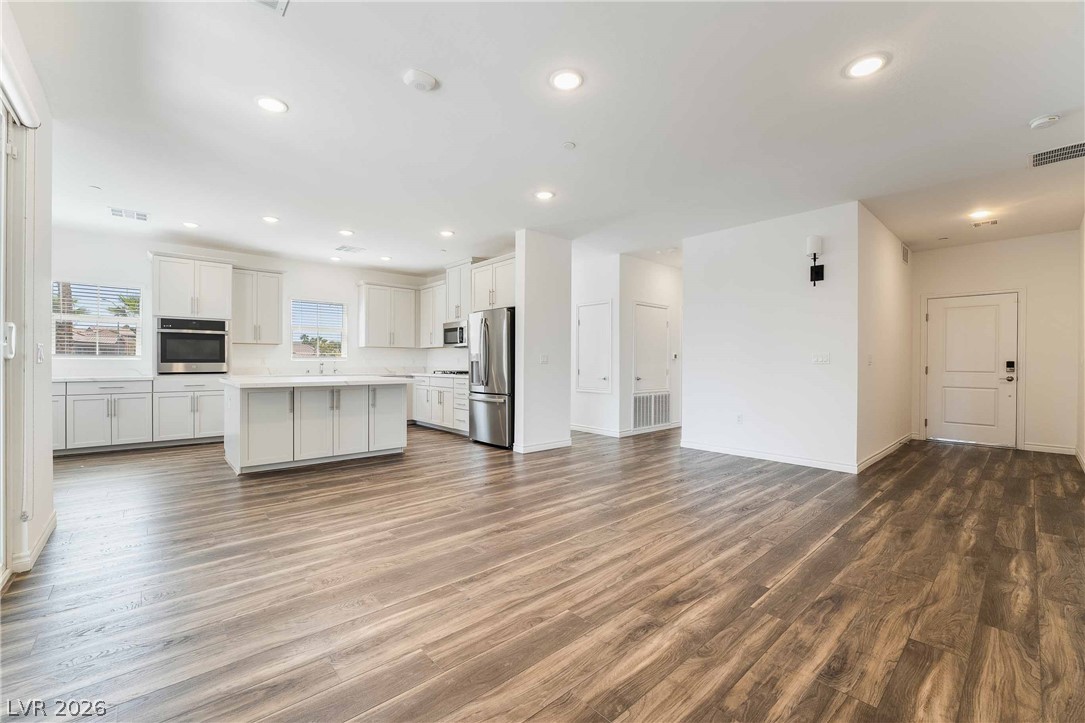 2555 Hampton Road, Unit 10202 Henderson, NV 89052 - Photo 6 of 35 Rich wood-inspired flooring anchors a spacious open living area leading directly into the modern kitchen.
