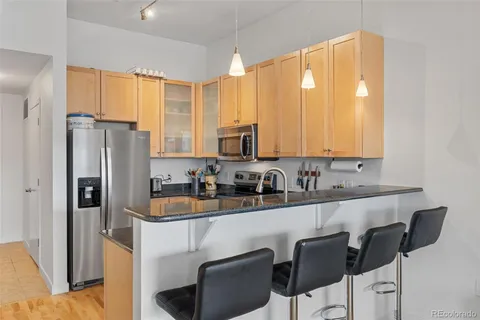 a kitchen with stainless steel appliances a sink a stove a refrigerator and cabinets
