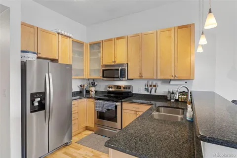 a kitchen with stainless steel appliances granite countertop a stove a sink and a refrigerator