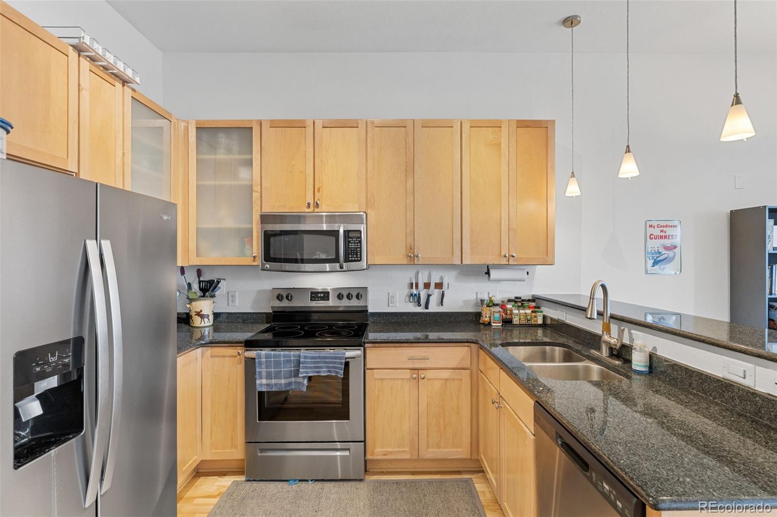 1555 Central Street, Unit 306 Denver, CO 80211 - Photo 20 of 36 a kitchen with stainless steel appliances granite countertop a stove a sink and a refrigerator