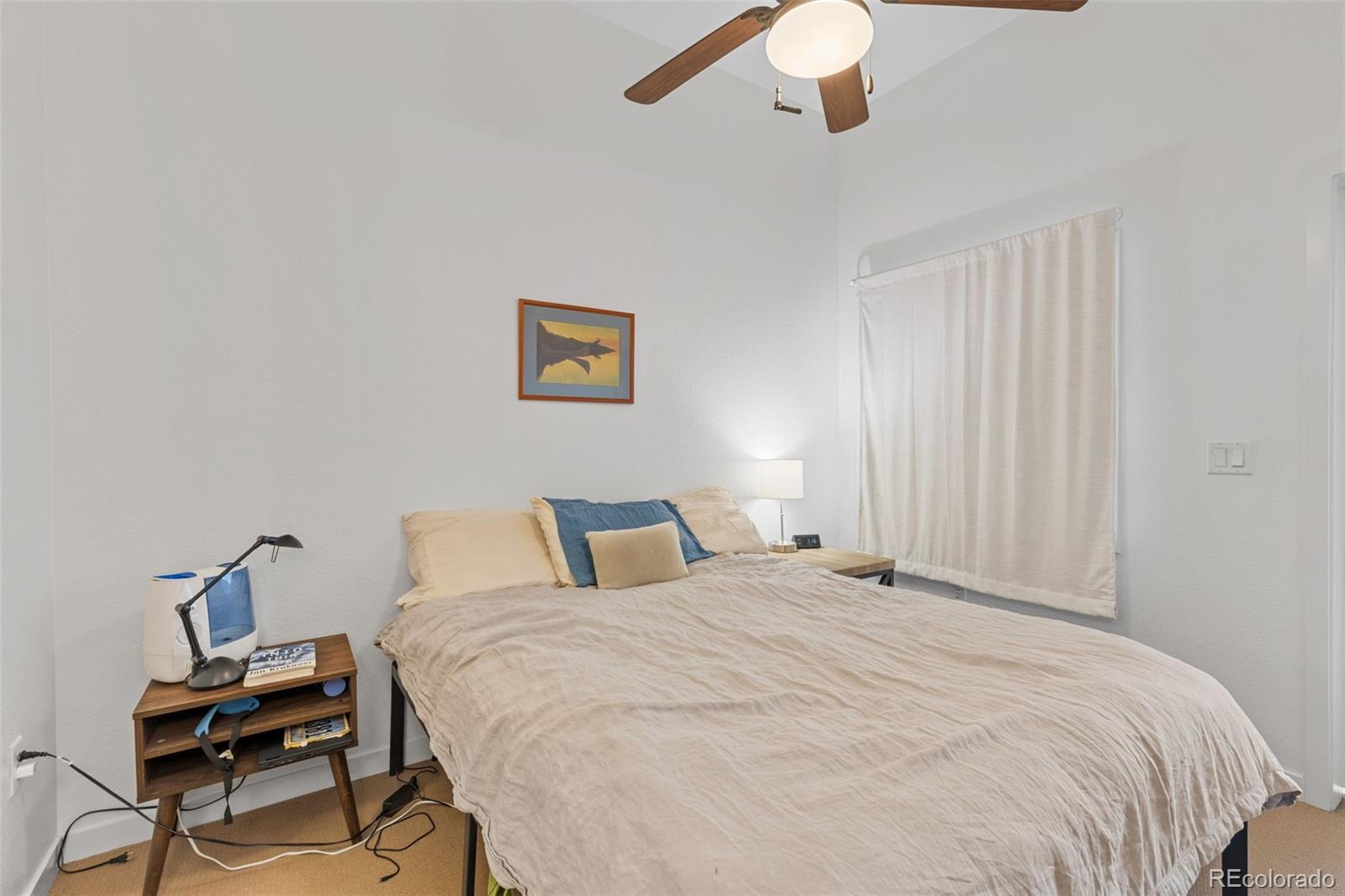 1555 Central Street, Unit 306 Denver, CO 80211 - Photo 26 of 36 a bedroom with a bed and a chandelier