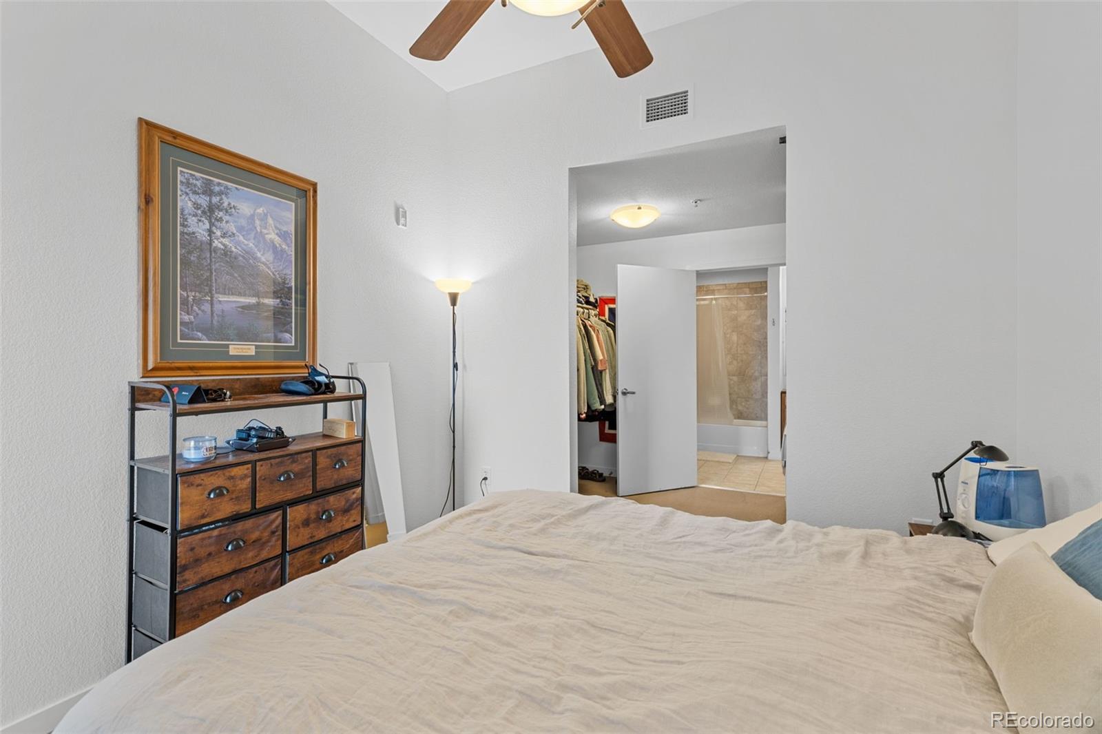 1555 Central Street, Unit 306 Denver, CO 80211 - Photo 27 of 36 a bedroom with a bed and a chandelier