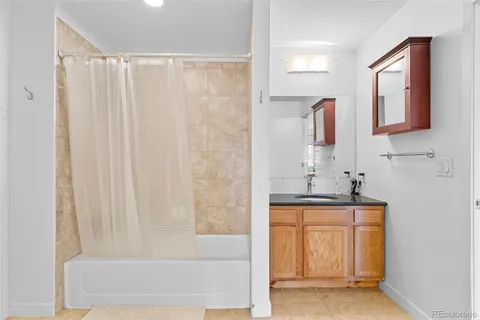 a bath room with a granite countertop sink and a mirror