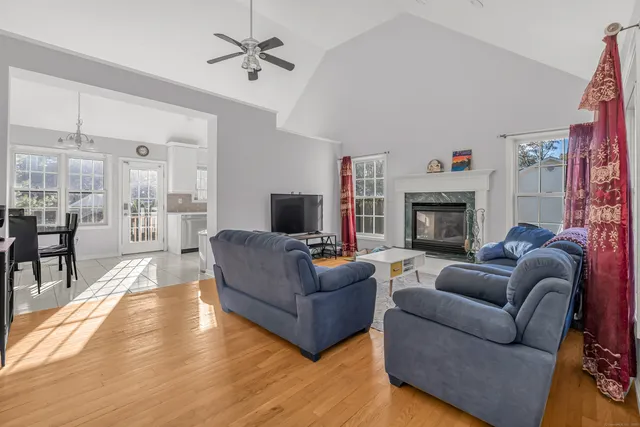a living room with furniture a flat screen tv and a fireplace