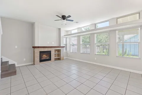 a view of an empty room with a fireplace and a window