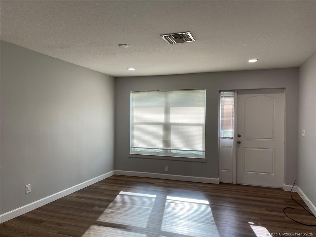 406 Robalo Court Stuart, FL 34996 - Photo 5 of 22 a view of an empty room with wooden floor and a window