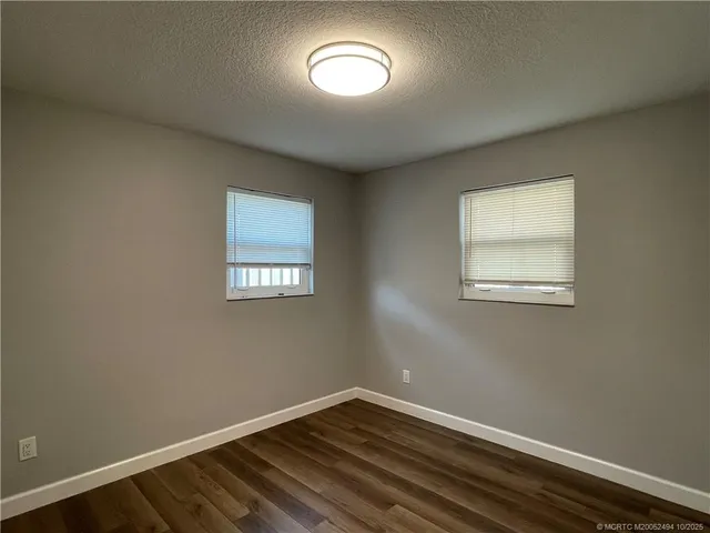 a view of a room with wooden floor and a ceiling fan