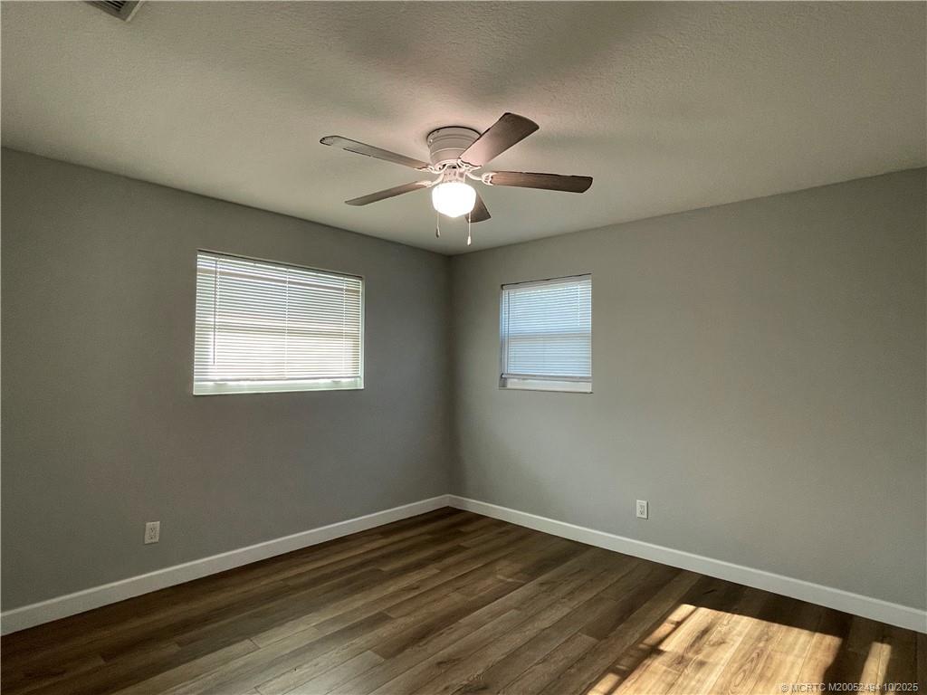 406 Robalo Court Stuart, FL 34996 - Photo 10 of 22 a view of a room with wooden floor and a ceiling fan