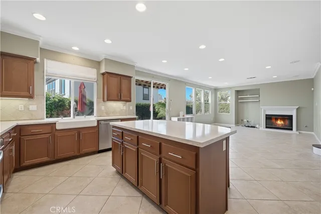 a kitchen with kitchen island granite countertop a sink and dishwasher stove with wooden cabinets