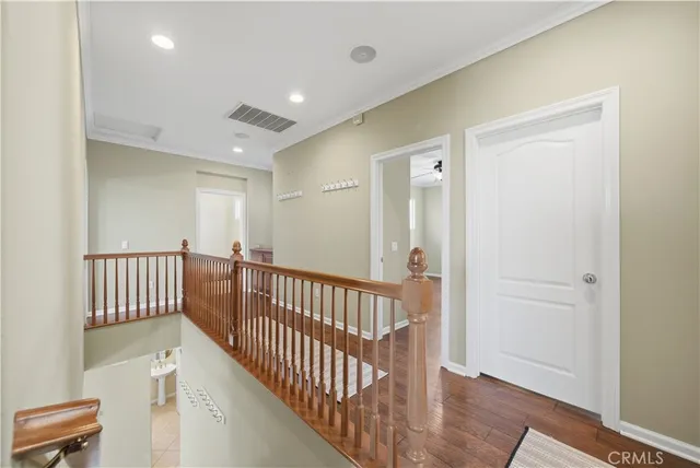 a view of a hallway with entryway and wooden floor
