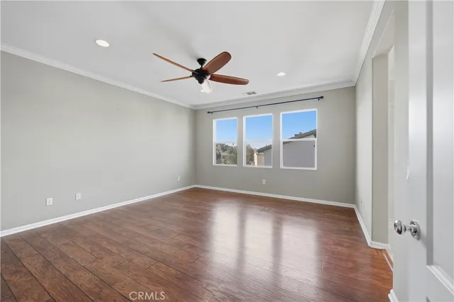 a view of an empty room with window and wooden floor