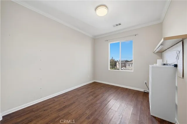 an empty room with wooden floor and white walls