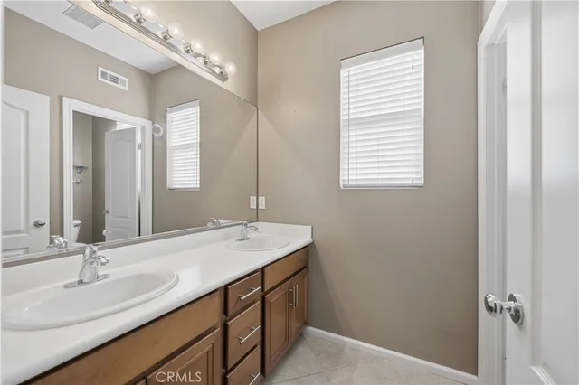 a bathroom with a double vanity sink and a mirror