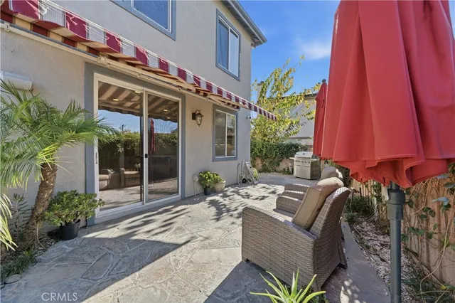 a view of a patio with couches and table and chairs under an umbrella
